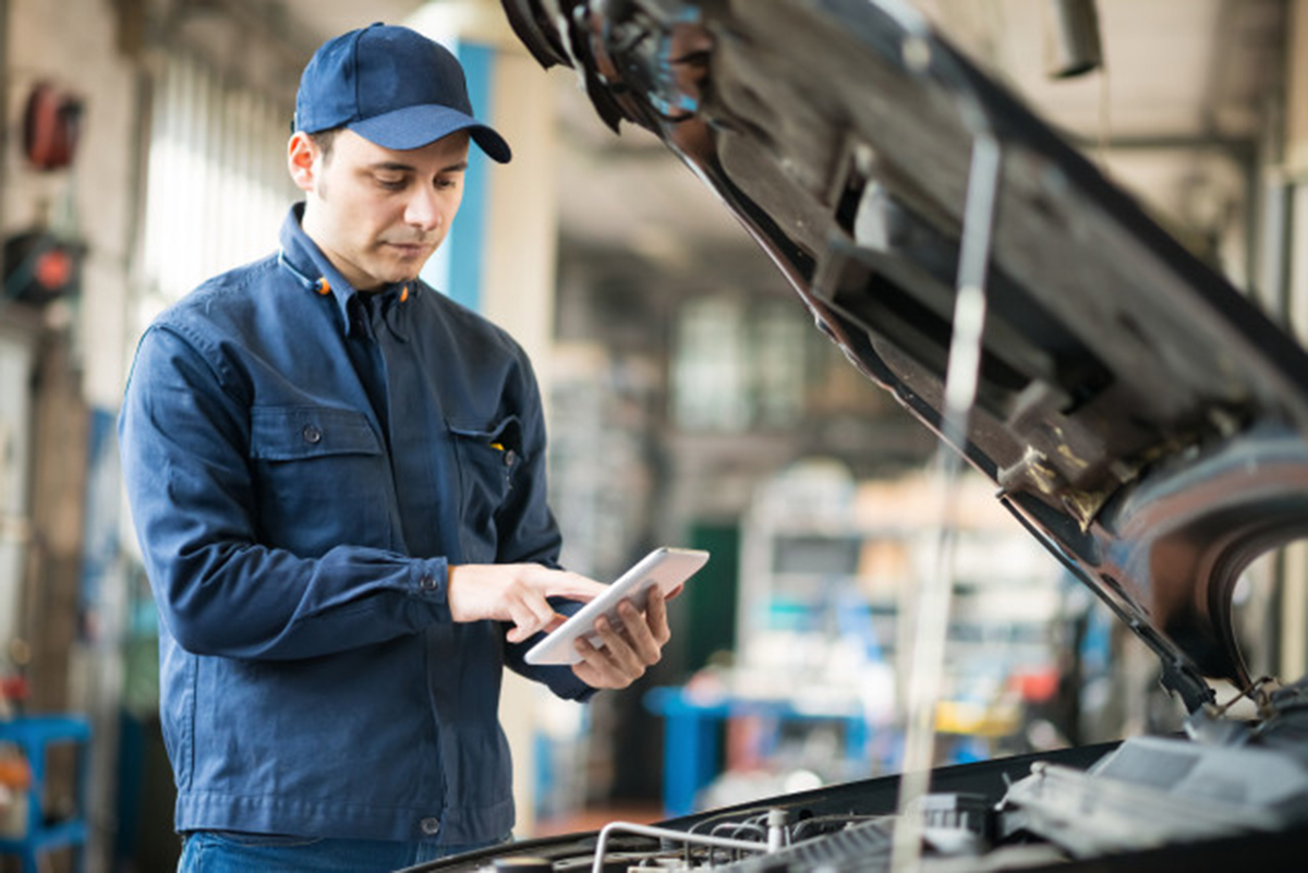 Mechaniker mit Tablet in der Autowerkstatt