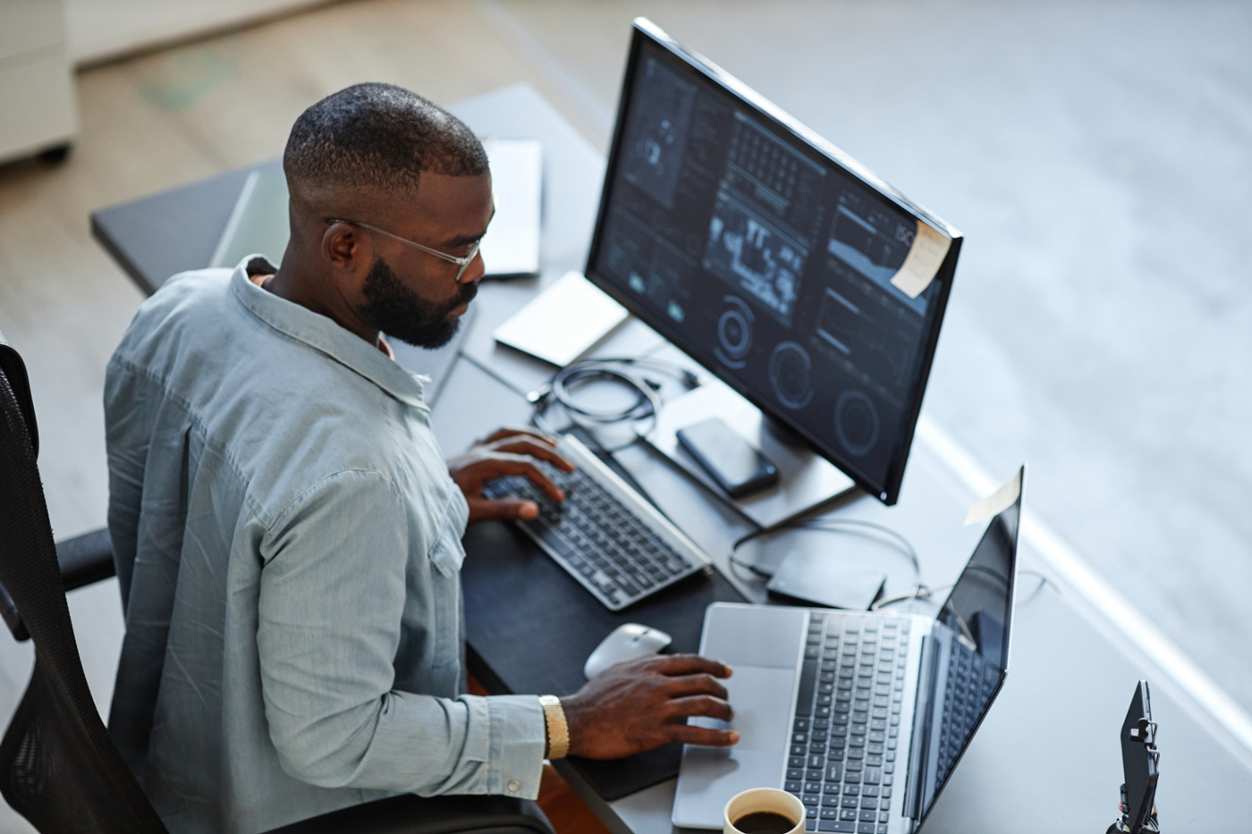 Developer in front of two screens, posed image